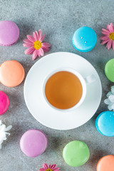 Photo of cake macarons, gift box, tea, coffee, cappuccino and flowers. Sweet romantic food macaroon concept. Morning breakfast and presents. Valentine's day concept.