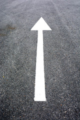 white arrow sign on the dry soil, ground, background