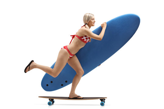 Young woman with a surfboard riding a longboard