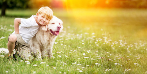 Junge geht mit Golden Retriever Hund Gassi im Park