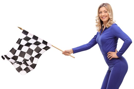 Young woman in a racing suit waving a checkered race flag