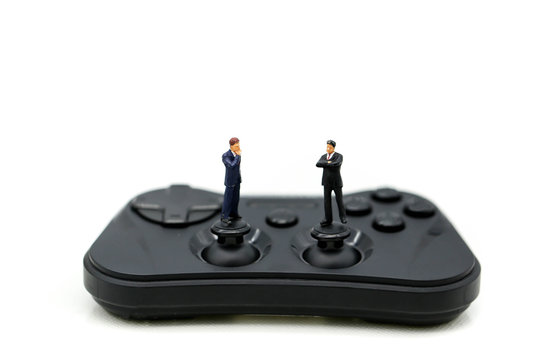 Miniature people : Buisnessman standing with joystick game to competition,Concept of success and competition
