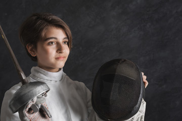 Fencer girl in fencing suit holding mask and sword