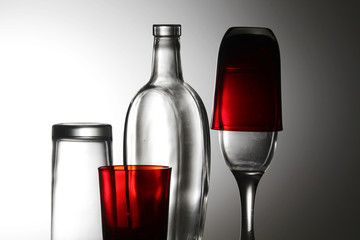 A transparent bottle and red glasses