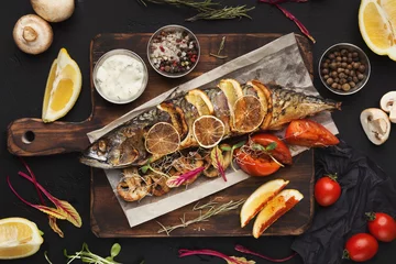 Fotobehang Gerechten Gegrilde vis op houten bord aan restauranttafel