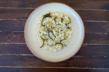 rice with zucchini in a rustic plate on a wooden table seen from above