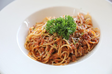 spaghetti Bolognese with minced beef and tomato sauce garnished with parmesan cheese and basil , Italian food