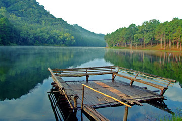 Fototapeta na wymiar Float wooden raft with seat chair float on the peaceful river among the green forest at Pang Ung in Mae Hong Sorn, Thailand