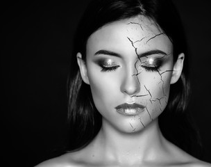 Woman with cracked face as cosmetic and dehydration effect concept.