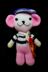 crochet yarn doll pink and white on black background