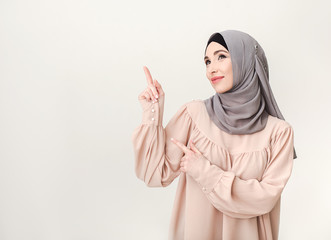 Islamic woman in hijab pointing on copy space