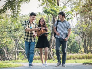 Obraz premium Group of college students walking and talking on campus