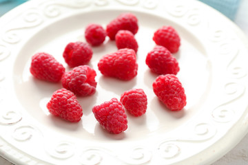 Sweet ripe raspberries on plate, closeup