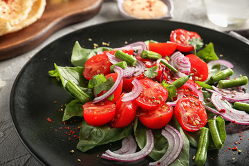 Plate with fresh vegetable salad on grey table, closeup