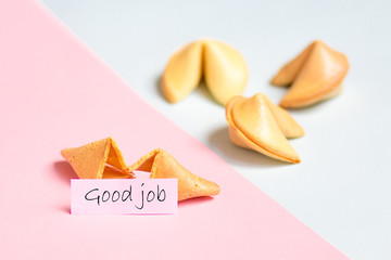 fortune cookie on pink and blue background, pastel colors, good job prediction