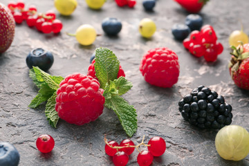 Delicious fresh berries on grey textured background