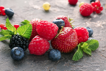 Delicious fresh berries on grey textured background