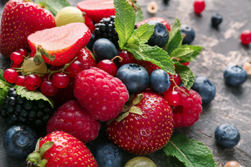 Delicious fresh berries on grey textured background, closeup
