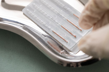 Ärztin nimmt Verpackte Akupunturnadeln aus Nierenschale zur TCM Akupunktur Behandlung 