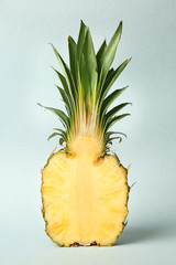 Half of ripe pineapple on light background