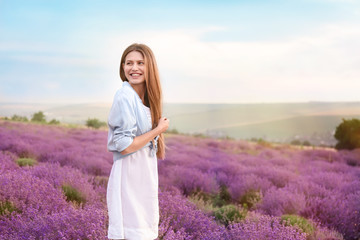 Beautiful young woman in lavender field on summer day