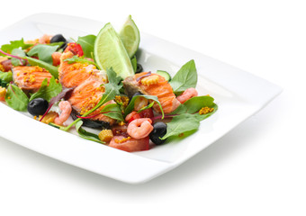 Plate with tasty fish and fresh salad on white background