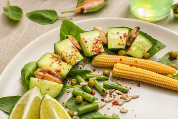 Tasty salad with mussels and vegetables on plate, closeup