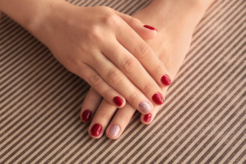 Female hands with stylish color nails on paper, closeup