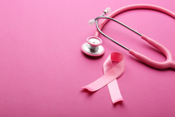 Pink ribbon and stethoscope on color background. Breast cancer awareness concept