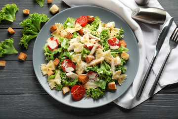 Tasty Caesar salad with pasta on plate
