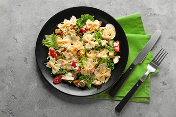 Tasty Caesar salad with pasta on plate