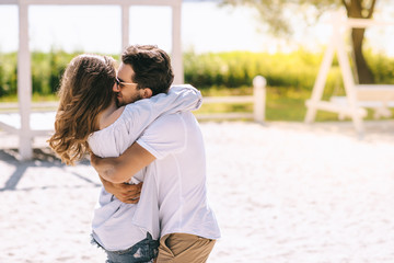 couple hugging at sandy city beach in summer
