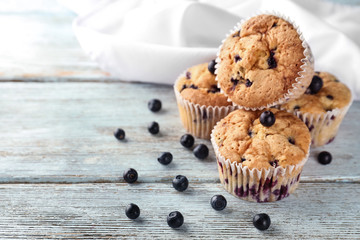 Tasty blueberry muffins on wooden background