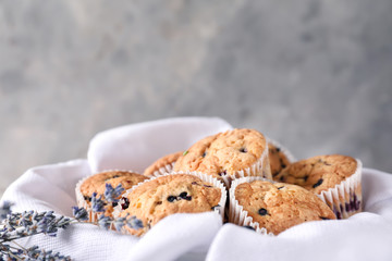 Tasty blueberry muffins on napkin against grey background