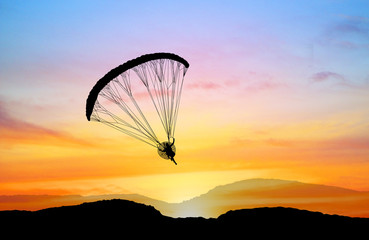 silhouette Para-motor flying on the sky  at sunset