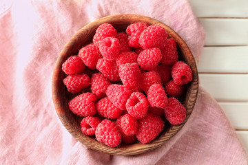 Delicious fresh ripe raspberries in bowl on table