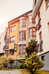 Fototapeta premium New multi-storey residential building. Modern house dyed in red and orange colors