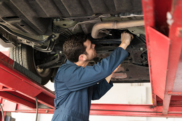 Fototapeta na wymiar Male Technician Servicing Car In Repair Shop