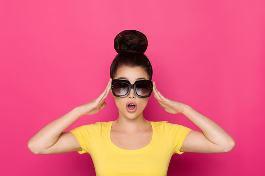 Surprised Young Woman In Sunglasses Is Holding Head In Hands