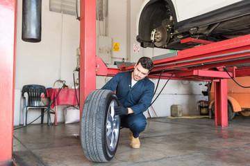 Mechanic Examining Tire For Replacement In Repair Shop