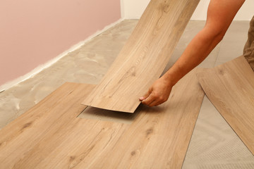 Fototapeta na wymiar worker installing new vinyl tile floor