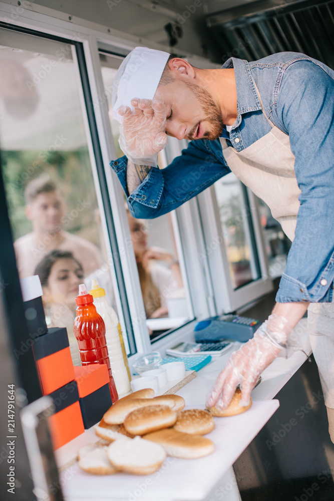 Wall mural tired chef working in food truck while customers waiting outside