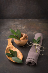 Fresh Bay Leaf; Leaves in Mortar and Pestle; Wooden Spoon; Black Background
