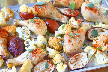Sheet pan dinner of chicken with vegetables and sage leaves
