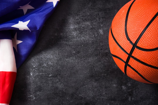 Basketball and USA flag on black slate background. Copyspace.

