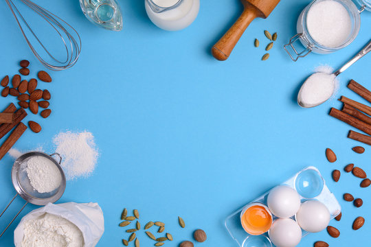 Baking ingredients for homemade pastry on blue background. Bake sweet cake dessert concept. Top view. Flat lay. Copy space