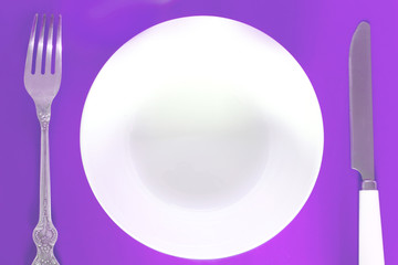 fork, knife and plate on a colored background