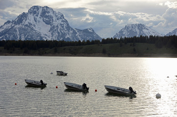 Boats anchored in Jackson Lake, Grand Teton National Park, Wyoming,  facing snow covered Mt Moran in background