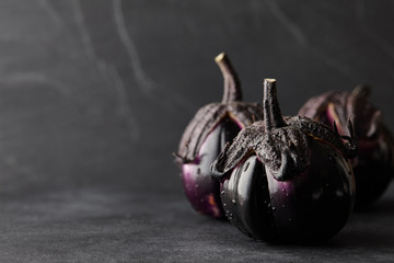 Fresh Italian type eggplants or aubergines with water drops closeup on black background