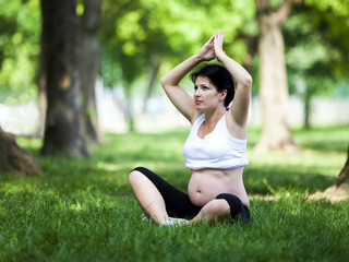 Naklejka na ściany i meble Young pregnant woman doing yoga exercises